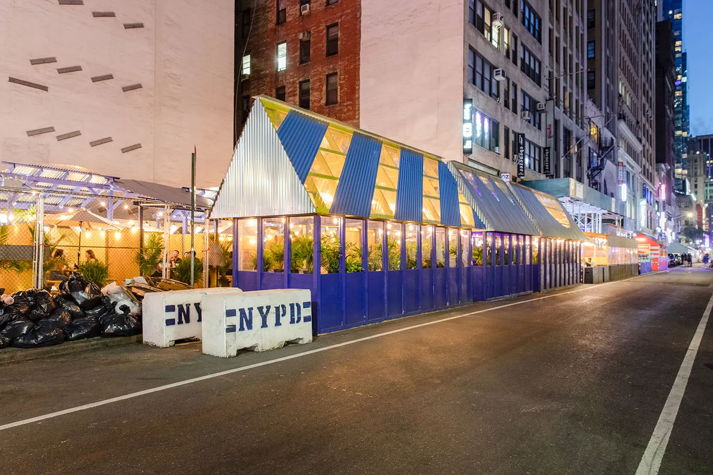 Striped blue and yellow roofs above the street at night