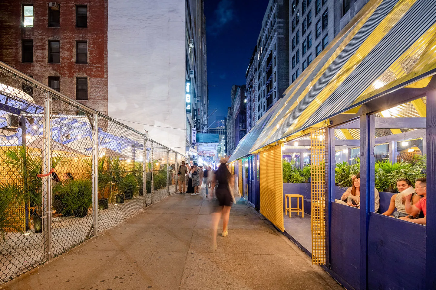 Diners inside the yellow-roofed booths at night