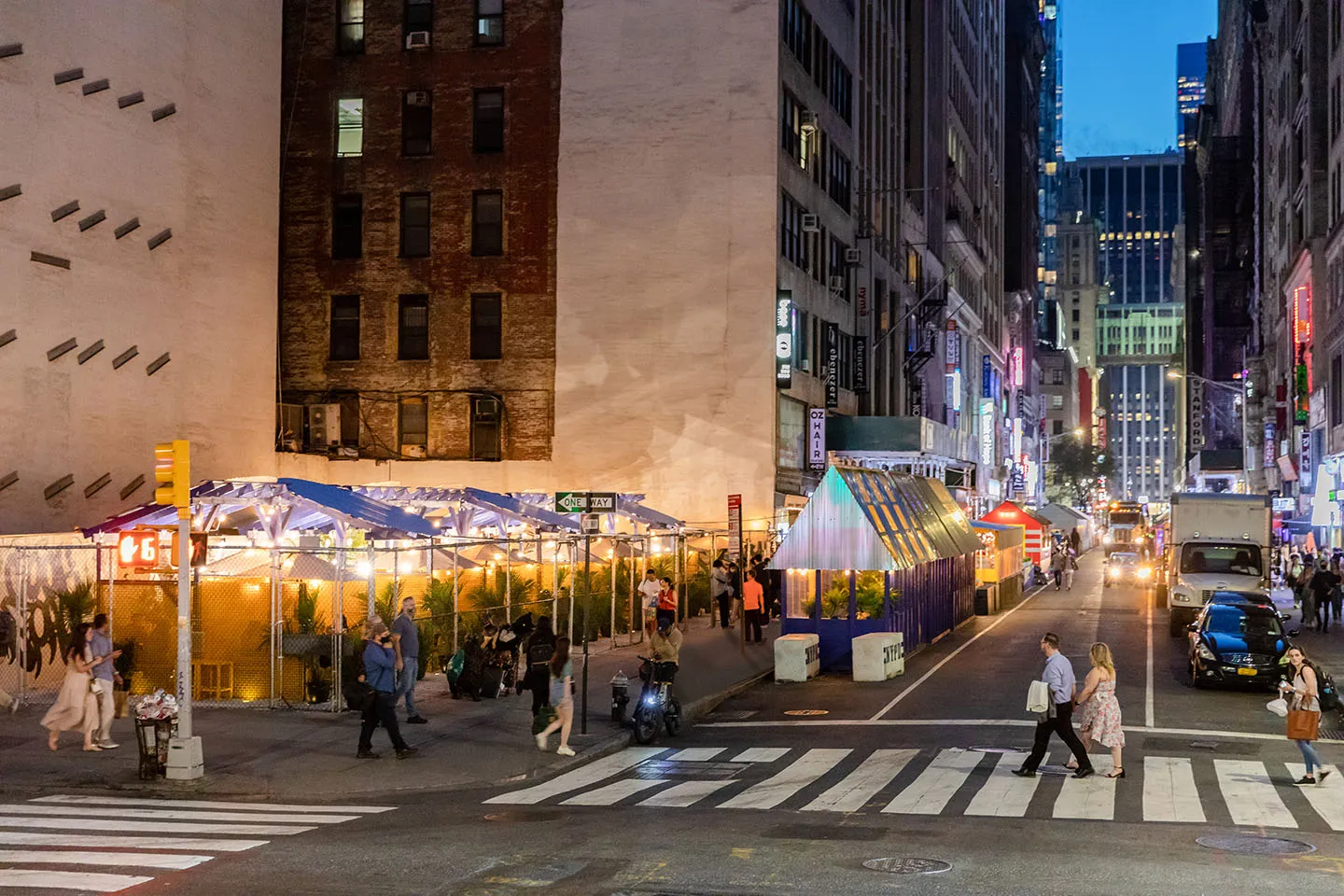 The streetery on 32nd Street at dusk, string lights glowing